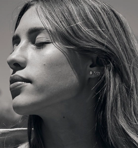 Detail view of S925 sterling silver square zircon stud and 1973 numeric earring on model
