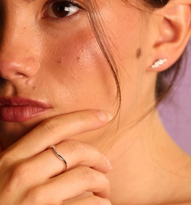 Détails de la bague diamant ondulée et des boucles d'oreilles irrégulières sur modèle