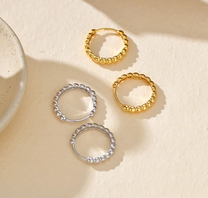Detailed shot of S925 sterling silver hoop earrings with bead texture and S925 hallmark