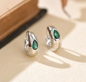 Détail macro d'une boucle d'oreille en argent S925 avec zircon émeraude en forme de poire