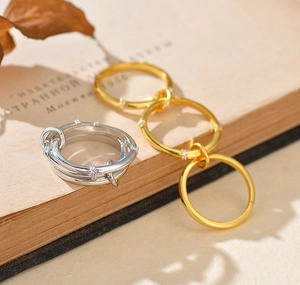 Dettaglio di anelli intrecciati in argento e oro con zirconi micro-incastonati su carta vintage