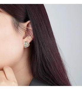 Close-up of S925 silver geometric triangle stud earring worn on model's ear
