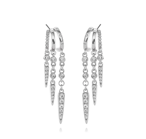 Close-up of silver tassel earrings with studded rivets and pavé crystal cone pendants