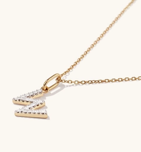 Macro shot of gold S925 silver letter W pendant with micro-pave cubic zirconia