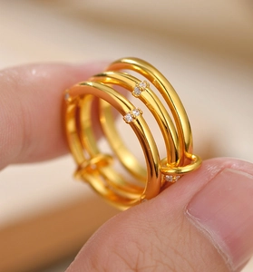 Dettaglio macro di anello a triplo strato dorato con pietre in zirconia micro-pave
