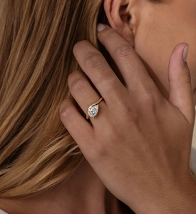 Elegant model wearing a pear-cut zircon ring with an 18K gold twisted wave band