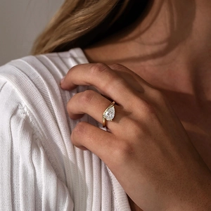 Elegant gold S925 silver pear-cut zircon ring worn by a model on a soft background