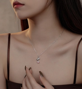 Close-up of S925 silver necklace with cute bear pendant and pink star gemstone on neck