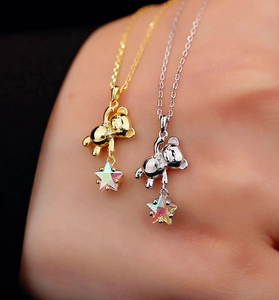 Detail of silver and gold necklaces featuring 3D bear and sparkling star charms