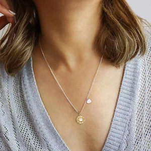 Détail du collier pendentif tournesol avec pierre zircon sur mannequin et cœur