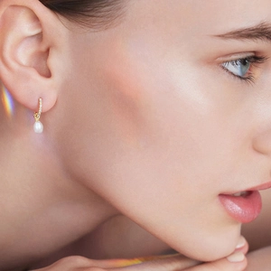 Elegant S925 silver gold-plated pearl drop earrings with zircon accents on model