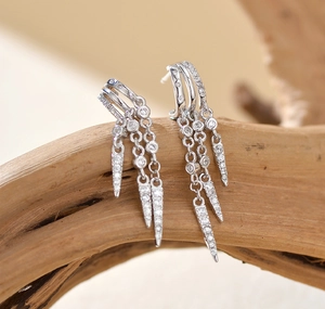 Macro detail of silver tassel earrings with glittering rhinestones and cone pendants