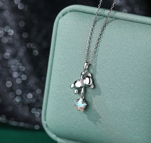 Detailed view of S925 silver teddy bear necklace with aurora star pendant on mint box