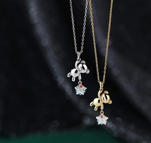 Detail of 3D bear pendants in silver and gold with colorful opal-like star charms