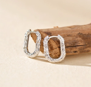 Detailed view of S925 sterling silver oval earrings with natural lava hammer texture