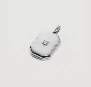 Detailed view of silver octagonal locket pendant with floral engraving and center stone