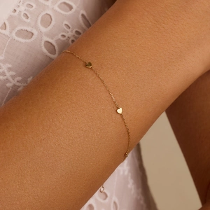 Minimalist S925 sterling silver gold heart bracelet on a woman wrist with lace sleeve