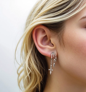 Close-up of S925 silver layered earrings with cross pendant and pave-set rhinestones