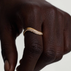 Irregular wavy gold ring with micro-pave white zircons shown on model hand