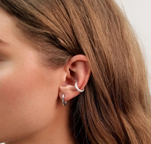 Close-up of S925 sterling silver oval hoop earring and textured ear cuff on model