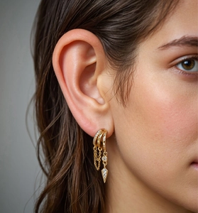 Close-up of a gold-plated S925 silver earring set with pavé cubic zirconia and dainty chains
