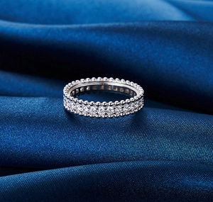 Detail eines s925 Silber-Eternity-Rings mit Diamanten und Milgrain-Rand auf Seide