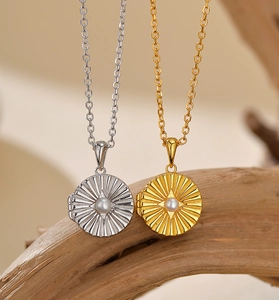 Detailed view of vintage gold and silver locket necklaces with pearl inlay and radial texture