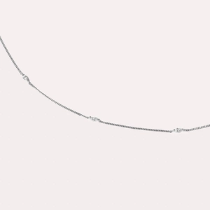 Close-up of minimalist silver chain bracelet with three marquise-cut sparkling zircon stones