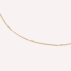 Macro view of gold box chain bracelet featuring three marquise-cut clear zircons