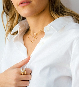 Detail of elegant crisscross ring with pavé diamonds on a model wearing white shirt