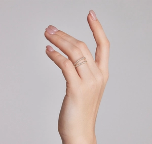 Macro detail of elegant double row pavé setting ring with gold finish on model's hand