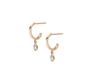 Detail of rose gold C-shaped earrings with sparkling round-cut bezel-set cubic zirconia