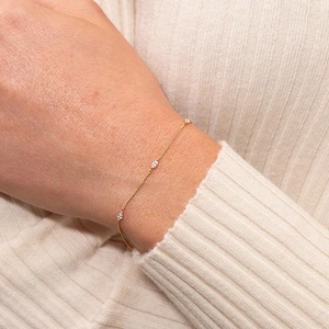 Minimalist gold link bracelet with three marquise-cut crystals on a model's wrist