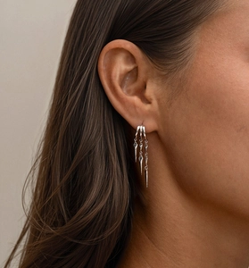 Macro shot of S925 sterling silver triple hoop earrings with long pointed cone pendants