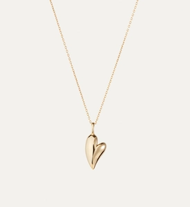 Macro detail of a 3D polished golden heart pendant on a delicate minimalist cable chain