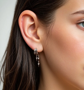 Detail of silver S925 tiered hoop earring with spiked chain tassels on a model