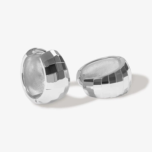 Dettaglio macro di orecchini a cerchio in argento sterling S925 con texture sfaccettata