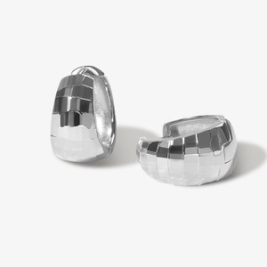 Dettaglio macro di orecchini a cerchio in argento S925 con sfaccettature geometriche