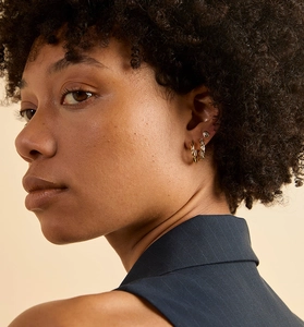Close-up of gold S925 sterling silver hoop earrings with pavé stones on a model