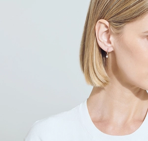 Close-up of a minimalist S925 sterling silver hoop earring with a round zircon pendant