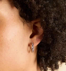Detail of S925 sterling silver hoop earrings with teardrop zircon worn by a model