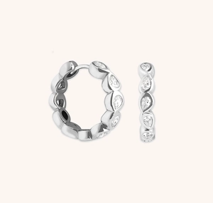 Detailed view of silver S925 huggie earrings with pear-cut cubic zirconia stones