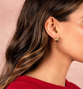 Close-up of chunky gold hoop earrings on model featuring a polished geometric design