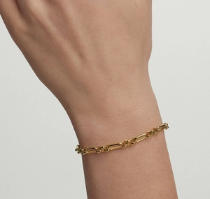 Close-up of minimalist gold paperclip link bracelet worn on wrist with sleek metallic finish