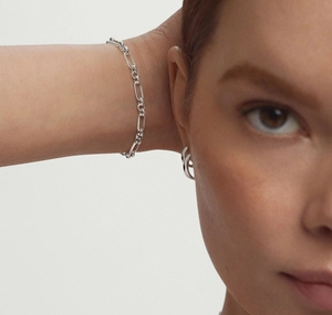 Polished S925 sterling silver chain bracelet and sleek hoop earring worn by a model
