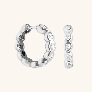 Elegant S925 sterling silver hoop earrings featuring pear-cut zircon stones on beige background