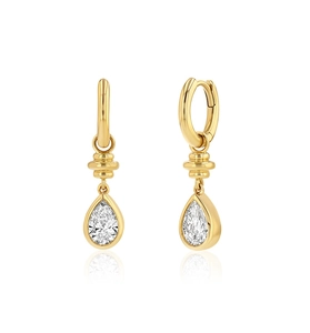 Macro view of gold huggie earrings with pear-cut clear zircon teardrop pendants