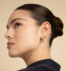Gros plan de boucles d'oreilles cœur en argent S925 avec zircons portées par un mannequin