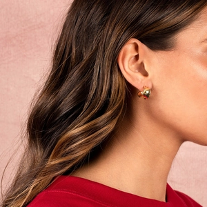 Minimalist C-shaped gold-plated sterling silver hoop earrings worn by a female model