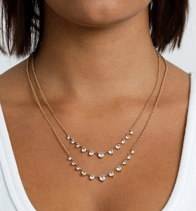 Gros plan d'un collier doré double épaisseur orné de zircons cubiques ronds brillants